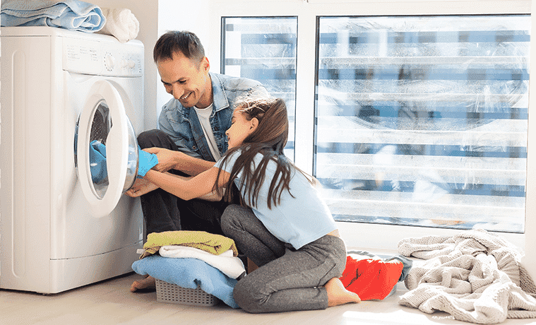 A father and daughter unload their dryer together.
