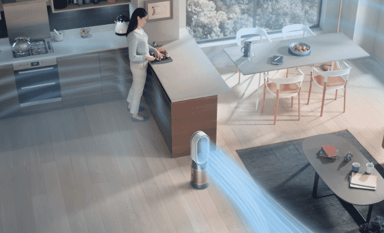 Woman prepares food as a Dyson purifier keeps her home fresh and clean