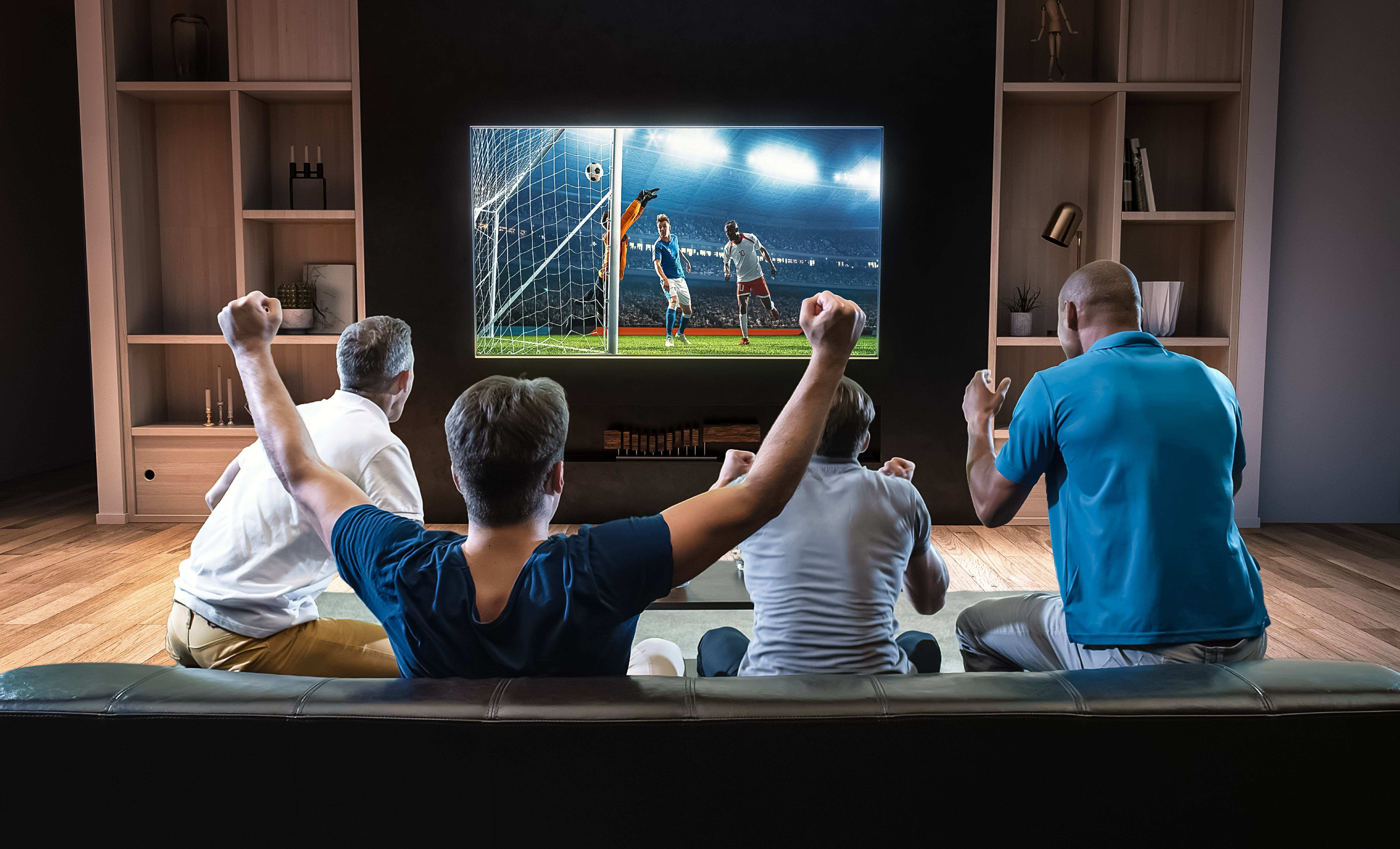 A group of friends watch a soccer game on TV.