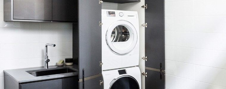 A stacked washer and dryer in a small laundry.