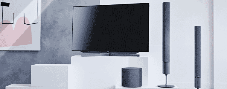 Two tower speakers stand next to a TV.