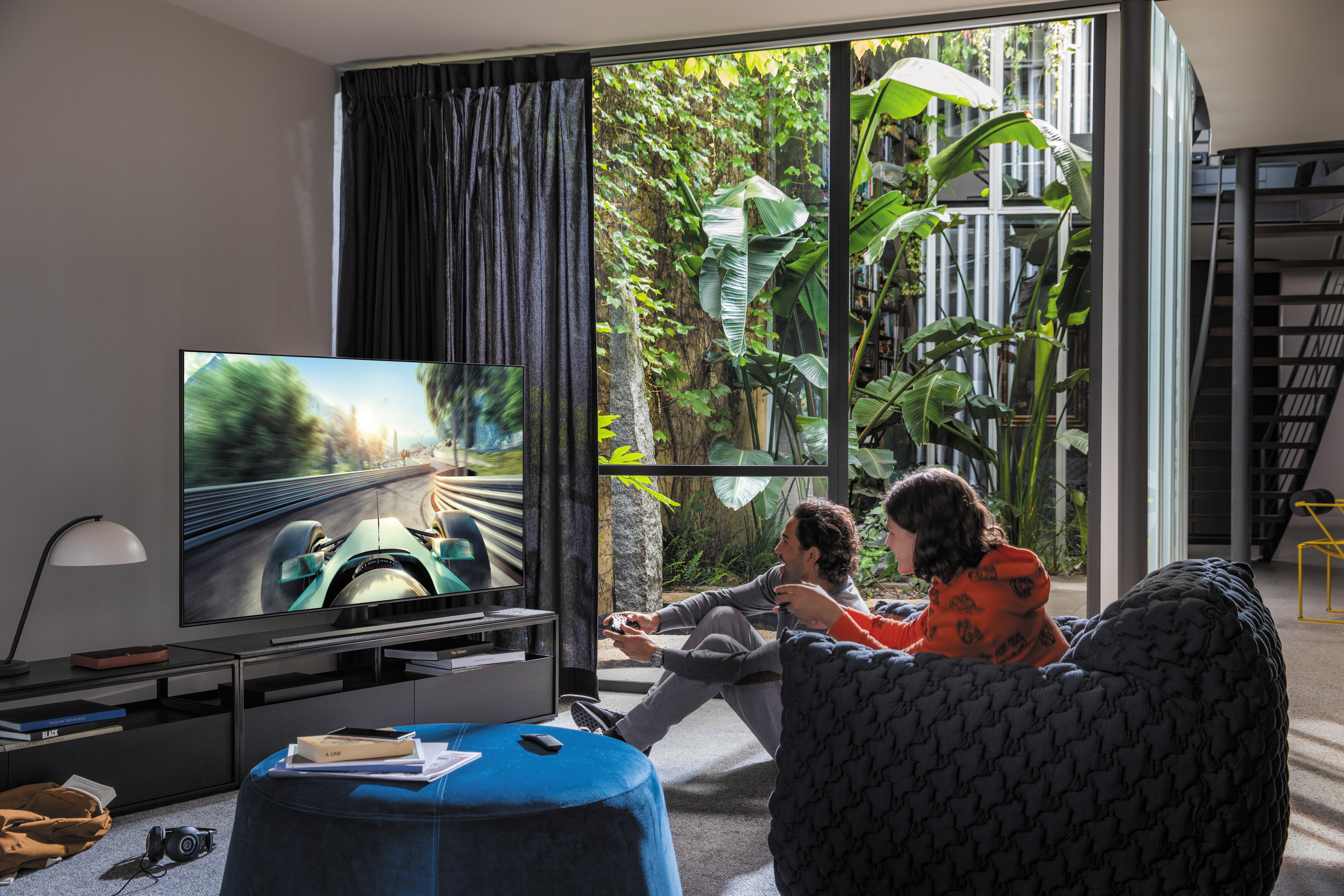 People playing video games on their new TV in a modern living area.