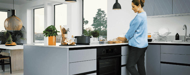 Woman prepares a meal using her new Chef Matte Black Kitchen Appliances from The Good Guys