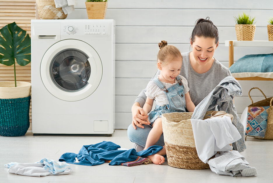 Mother and Daughter happily complete washing in family laundry
