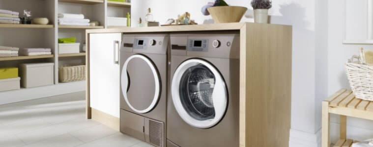 A match washer and heat pump dryer in a neutral-toned laundry.