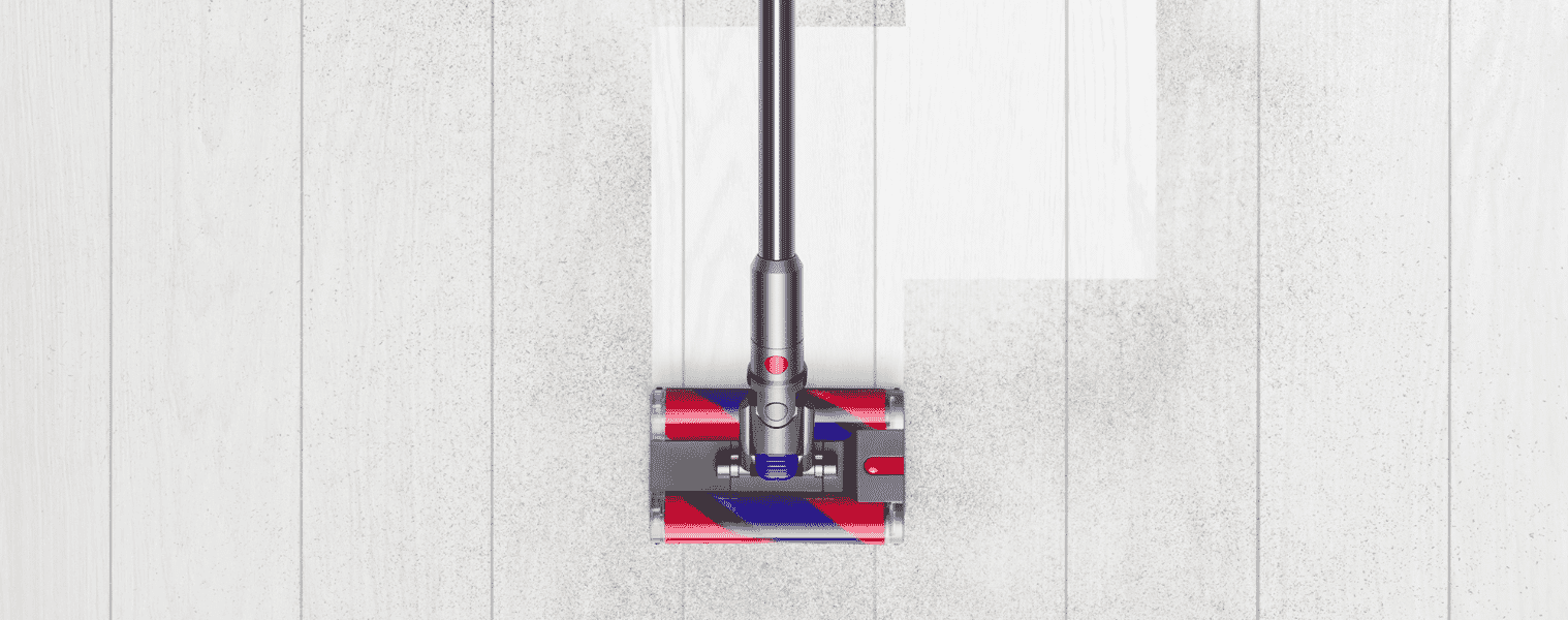 The Dyson Omni-Glide easily vacuums dirt and dust on a white floor.