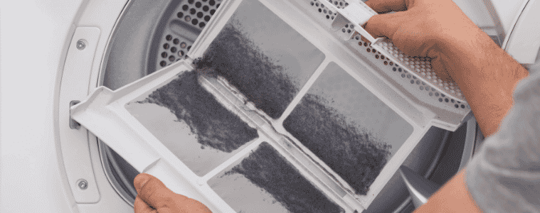 A person clears the lint from the lint filter.