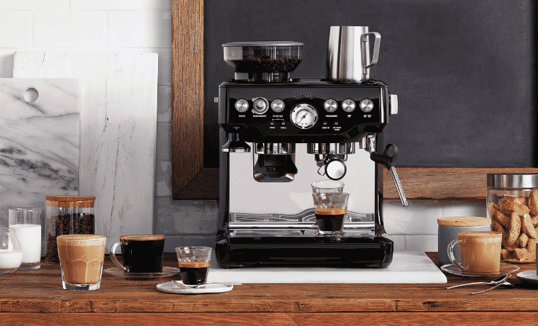  Beautiful Breville the Barista Express Coffee Machine sitting on a wooden benchtop surrounded by cups of coffee.