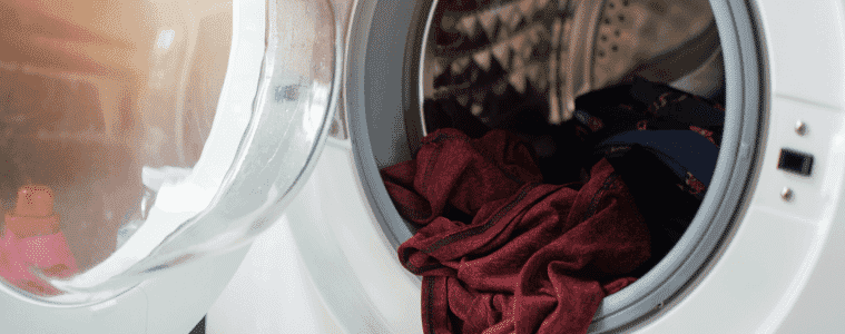 An open dryer with clothing inside.