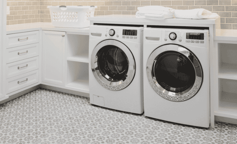 A washing machine and dryer sit side-by-side in a white, modern laundry.