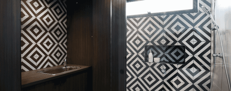 A compact laundry and bathroom with bold patterned tiles