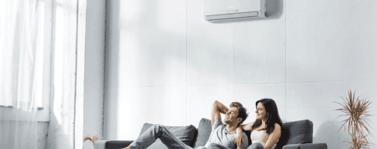 A couple relaxes with air conditioner cooling their space 