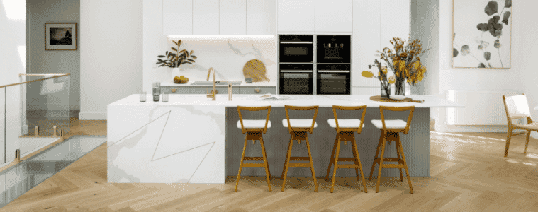 White coastal kitchen with white marble-look island and splashback