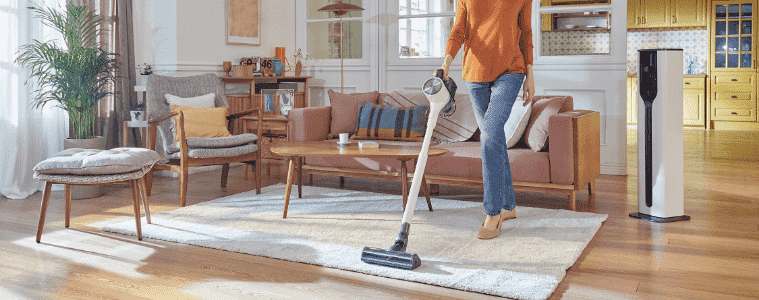 A lady vacuuming her house using the LG handstick vacuum