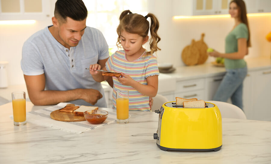 A father and his daughter make toast together with their toaster
