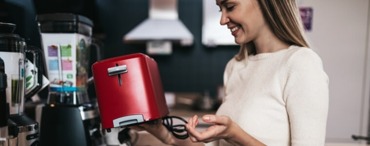 Woman happily looking at small kitchen appliances during the Black Friday Sale.