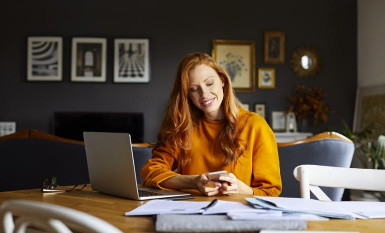 Woman working from home with her laptop, tablet and smartphone