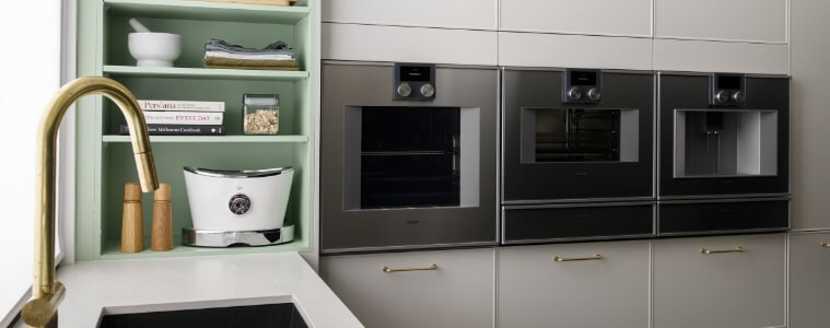 White and taupe kitchen with matte black appliances and deep storage drawers for small appliances.