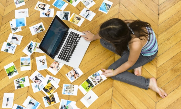 A young girl sorts and prints pictures from her holidays.