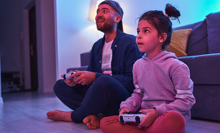 A father plays games with his young daughter.
