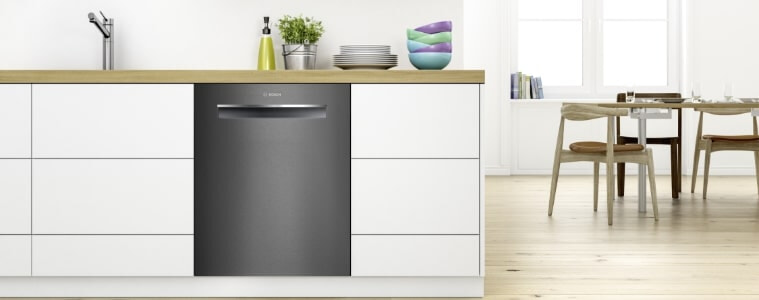A dark stainless steel dishwasher in a small kitchen.