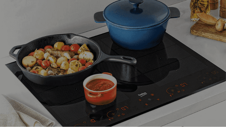 Induction cooktop with multiple pots and pans cooking food on the cooktop.