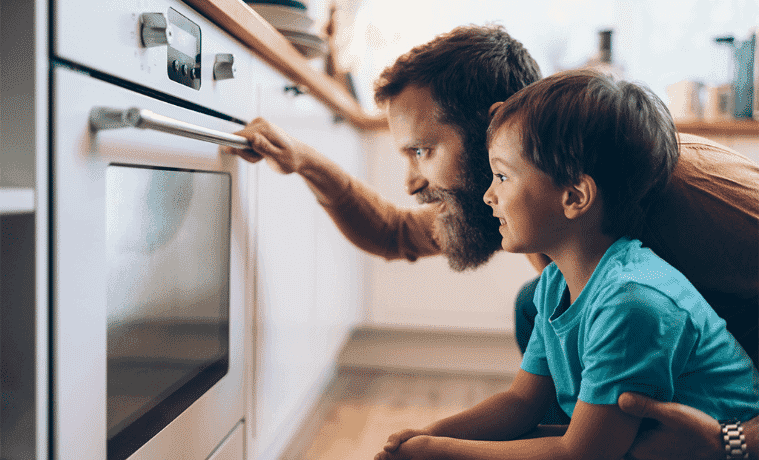 Dad has his arm around his small son as they intently watch their pyrolytic oven blast away the grime.