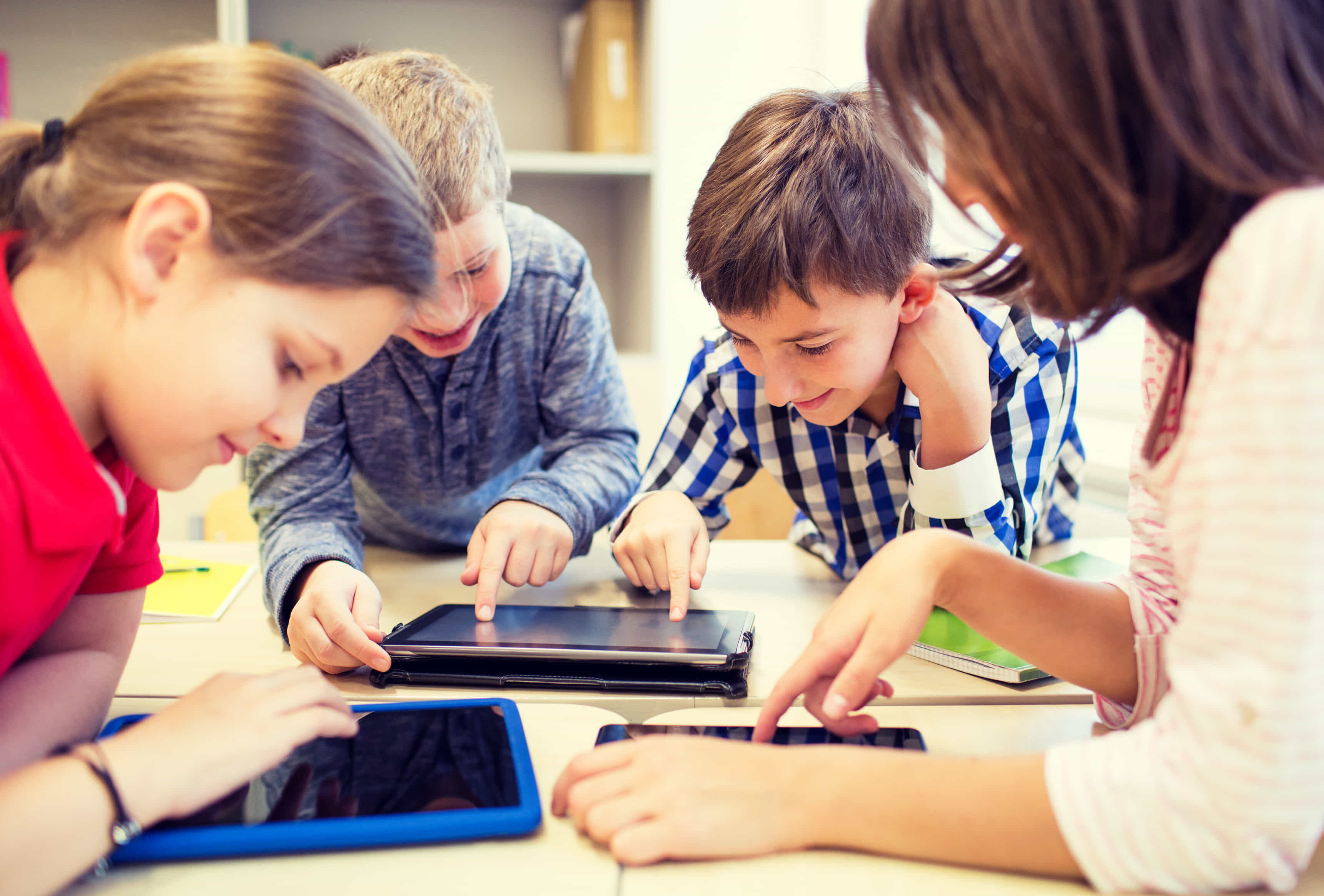 Multiple kids using their tablets in a classroom
