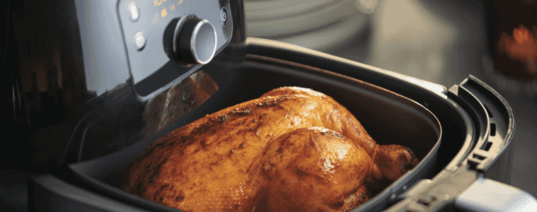 Open Philips AirFryer XXL showing a perfectly cooked chicken
