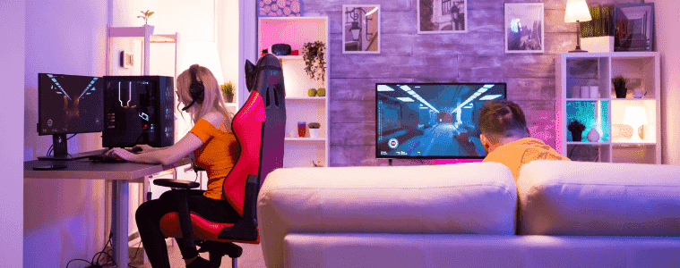 Guy and girl gaming on different screens in the same gaming room