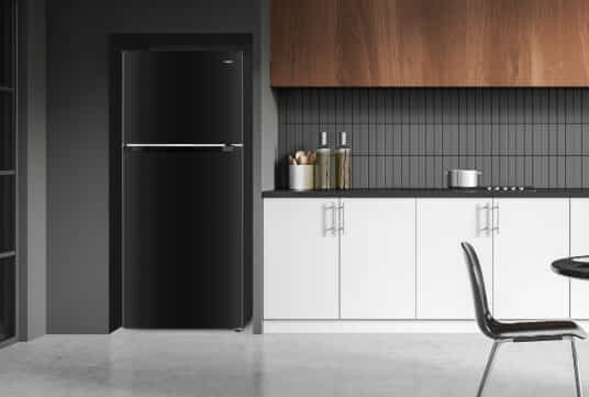 The black 202L Top Mount Fridge by CHiQ sits in a white and grey kitchen with warm timber accents.