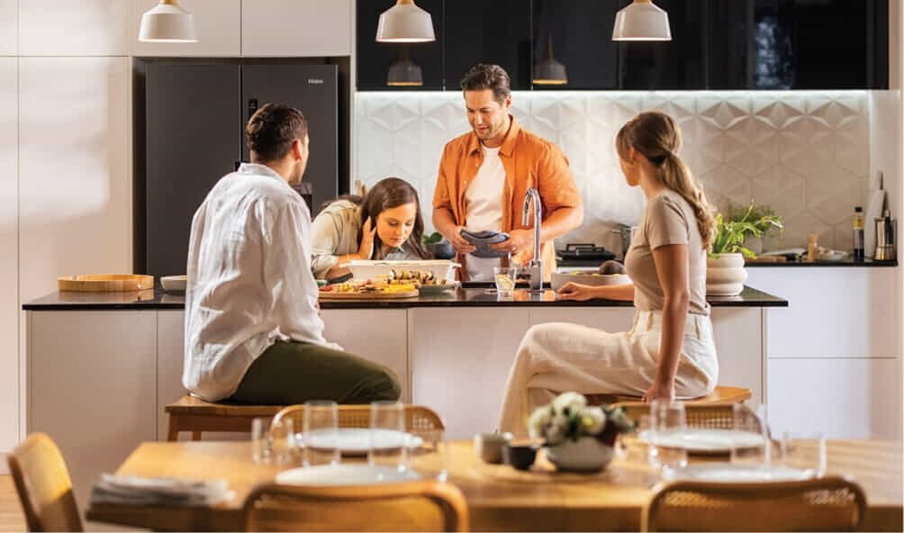 A group of friends share a meal in their Haier kitchen.