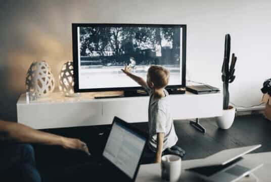Small boy interacting with the TV. 