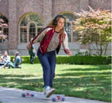 Lady on skate board wearing a headphone. 