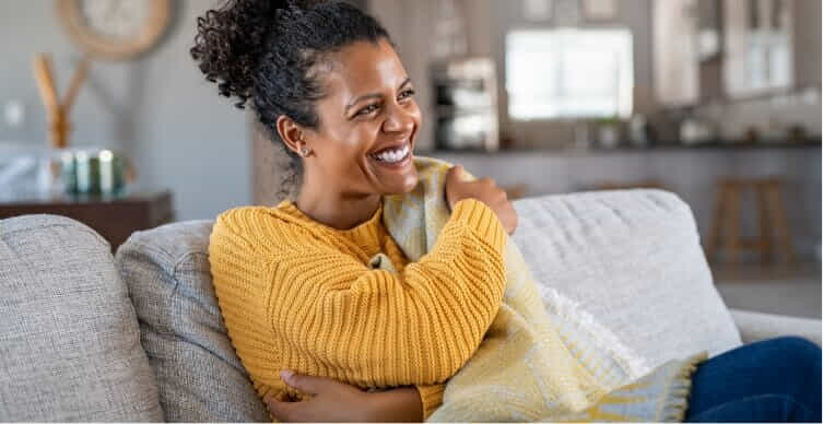 Woman cosy on her couch with the heater running