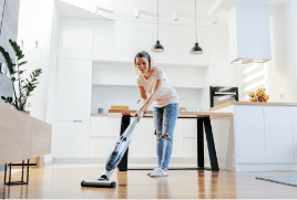 Lady vacuuming the hardwood floors in her dining room.|The Good Guys