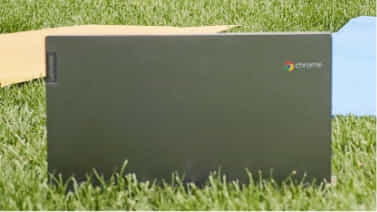 Chromebook sitting in grass outside.