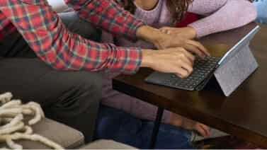 Father using his Chromebook with this daughter at home.