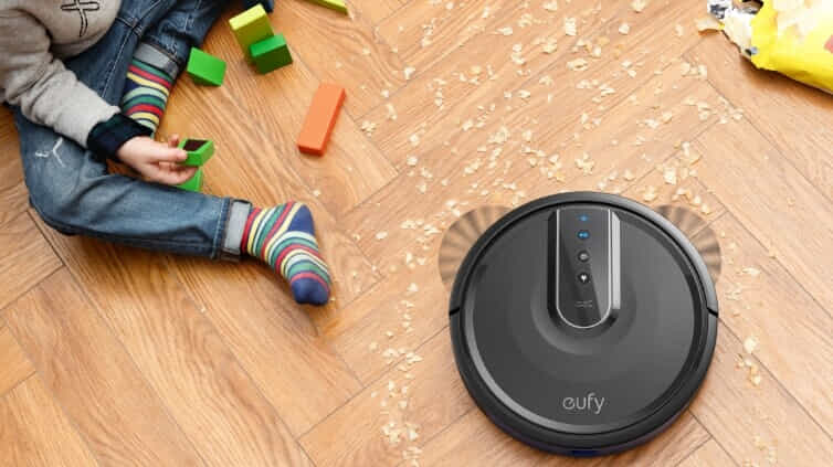 Eufy robot vacuum cleaning up the crumbs around a child playing with blocks.