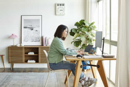 Female sitting at a desk with a desktop computer.