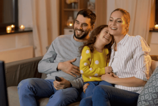 Family sitting on the couch watching some TV together