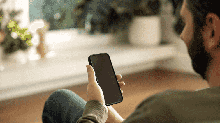 A male holding a phone in his hand