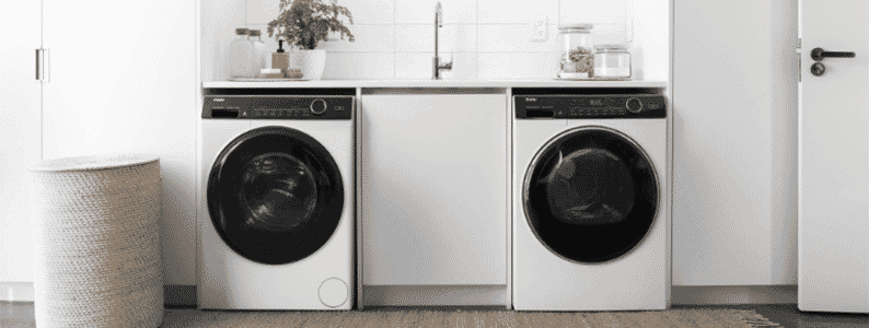 Matching Haier washer and dryer situated under a white benchtop in the laundry | The Good Guys