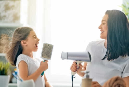 Girl and Mum having fun drying their hair