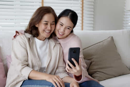 Woman teaching her older Mother how to face time.