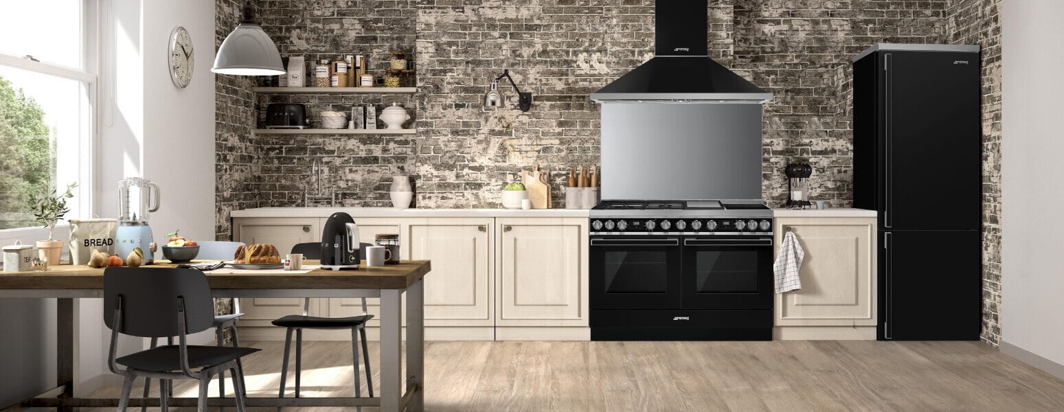 A black Smeg duel fuel cooker sits in a cream coloured kitchen