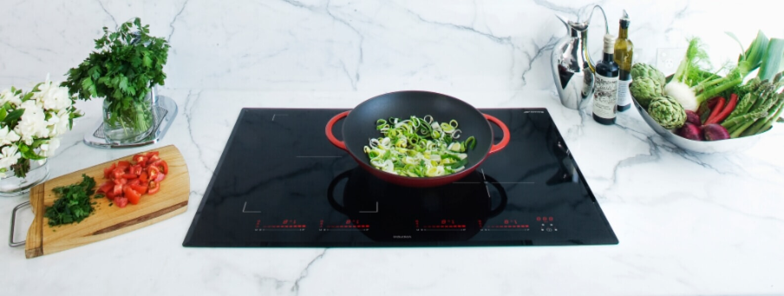 Spring onions are cooked on a Smeg ceramic cooktop