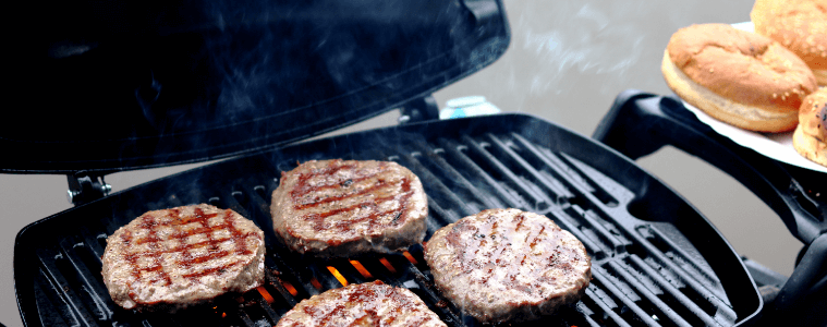 Cooking burger patties on a weber baby Q BBQ. 