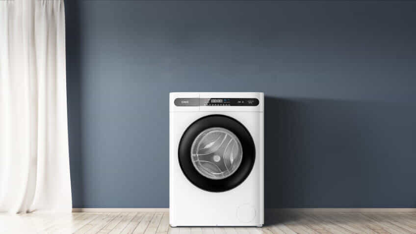 A CHiQ top load washing machine sits in a white laundry.