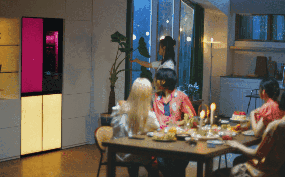 Woman entertaining her friends seamlessly at home with an LG MoodUP fridge.